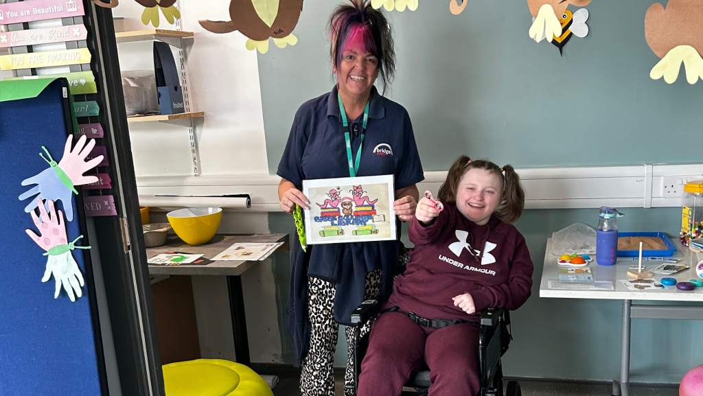 Millie and her support worker showing off the winning sign!