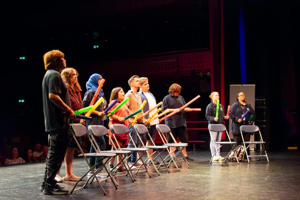 A group of students and teachers on the stage.