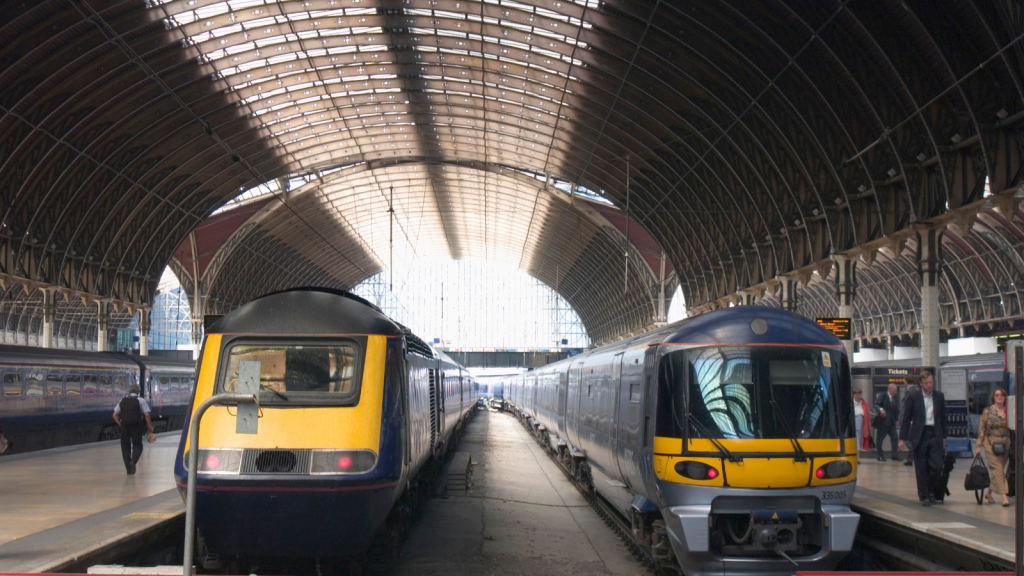 Two trains pulled into a large train station.