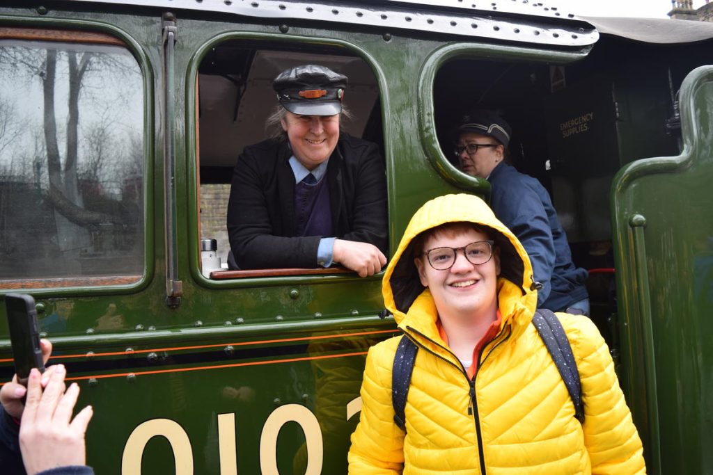 One of the students smiling with the train driver.