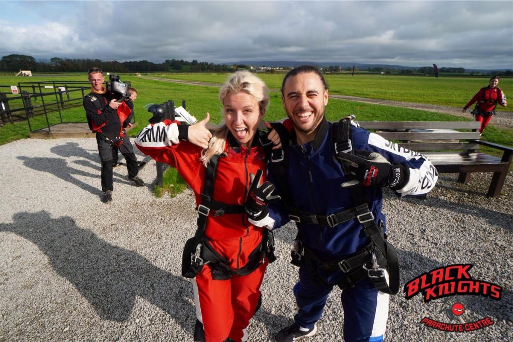 a staff member with an skydiving instructor giving a thumbs up