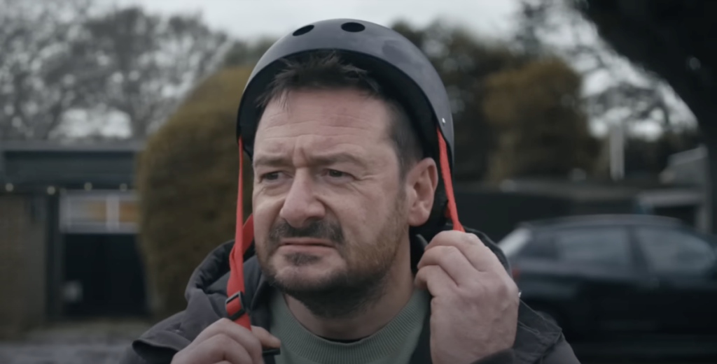 image of a man putting on a cycle helmet