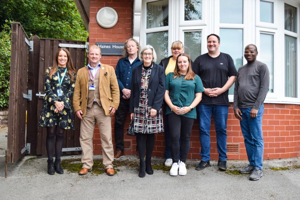 Together Trust staff and the Deputy Lord Mayor of Salford standing in front of a home