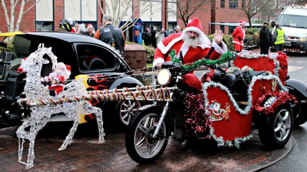 a Roughley's biker dressed as Santa stood next to a motorbike
