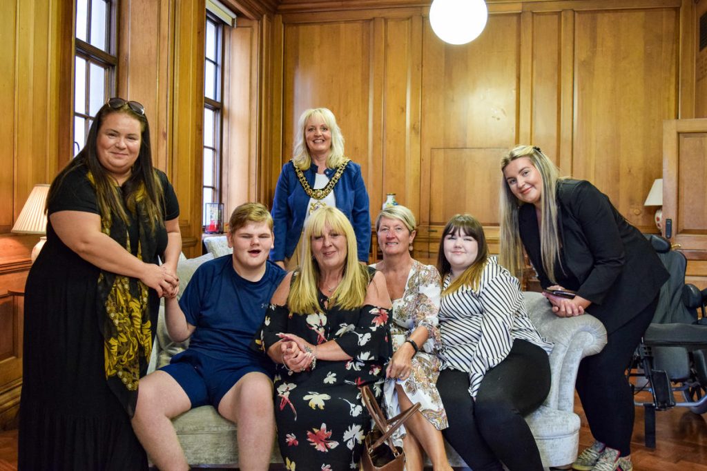 Lord Mayor of Manchester Councillor Donna Ludford with young people and staff from Together Trust sat on a sofa