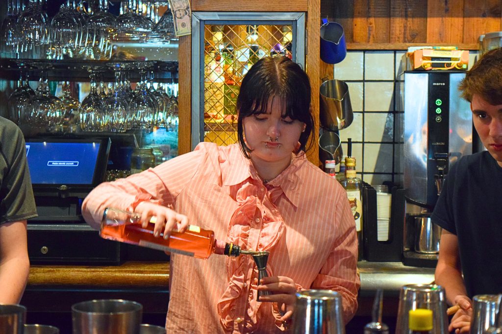 A student crafting the classic Virgin Mojito behind the bar.