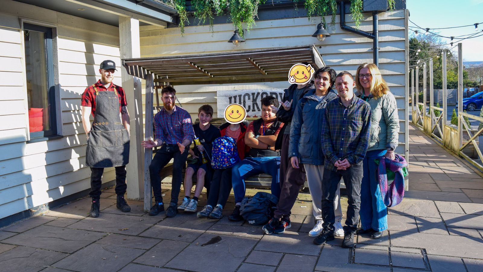 A group photo of five students—Dave, Jack, and Mikey, alongside careers teacher Marie Young, smiling at the camera outside Hickory’s restaurant.