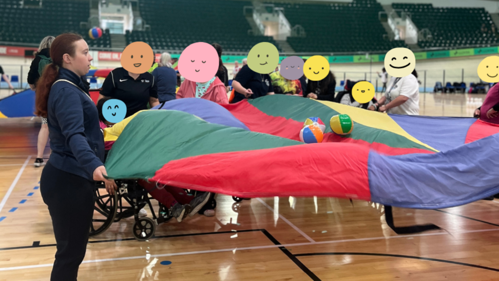 The MAPT coach holding a corner of a colourful parachute with students and teachers from different north west special schools and colleges.