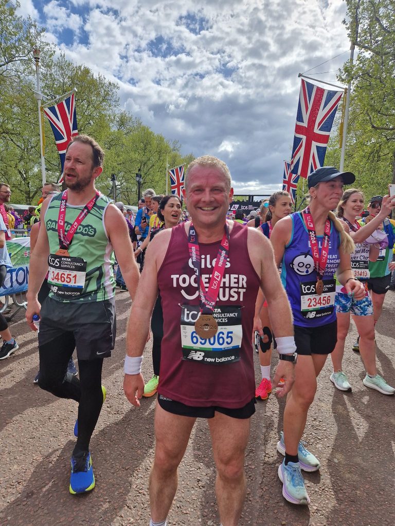 Giles with his medal wearing a together trust vest