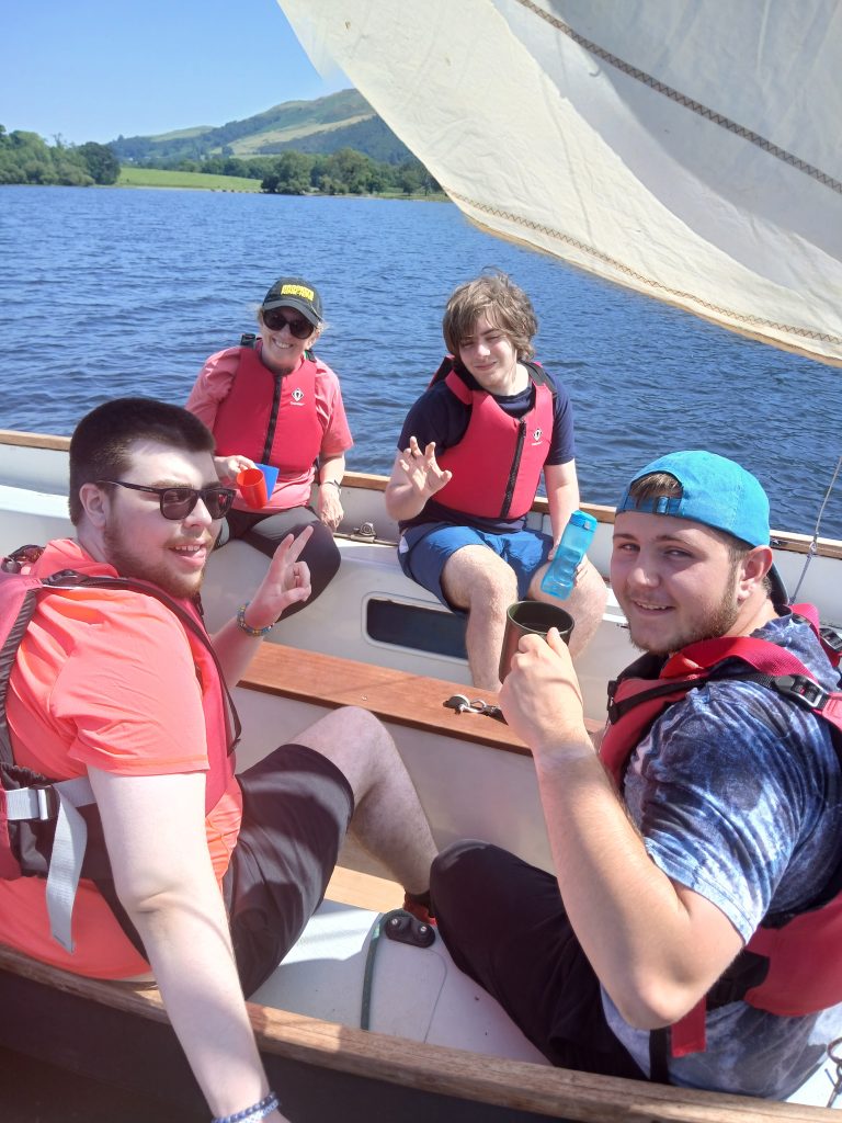 three students and a teacher post on the boat