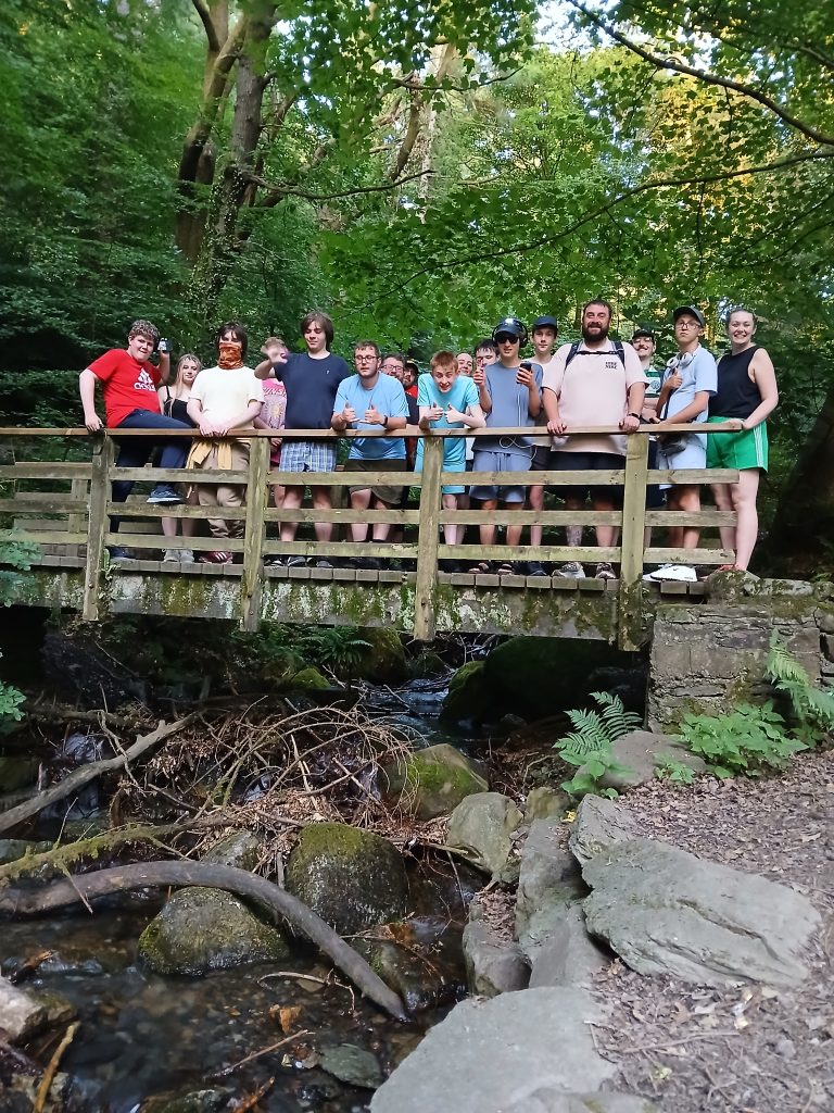 a group of students and teachers pose on a bridge