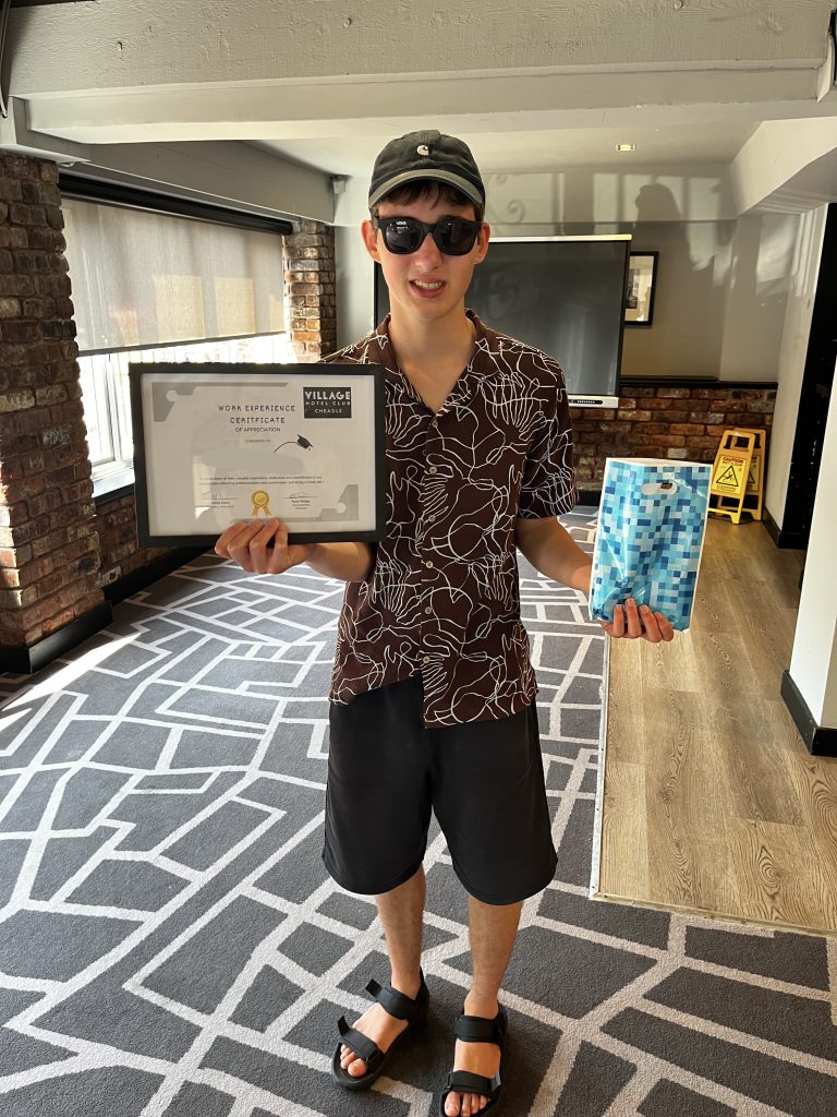 a teen boy is showing off his certificate and a goody bag
