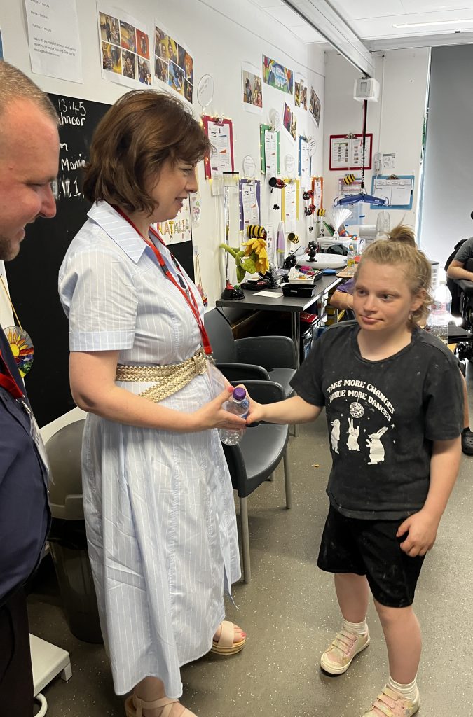 Lucy and Thomas greet a student