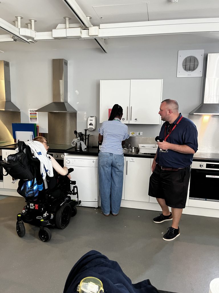 Thomas talks to a student in a wheelchair