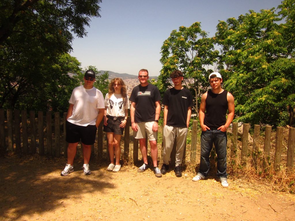 A group of students and staff member posing in front of a viewpoint