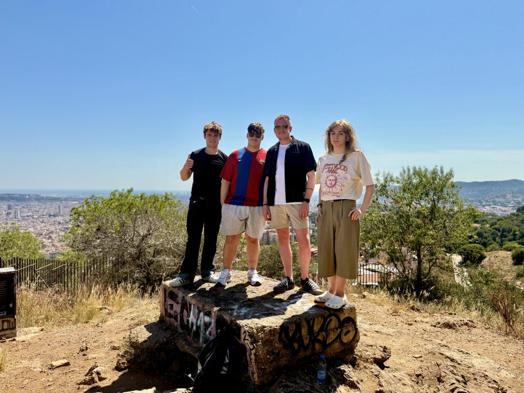 A group of students and staff member posing in front of a viewpoint