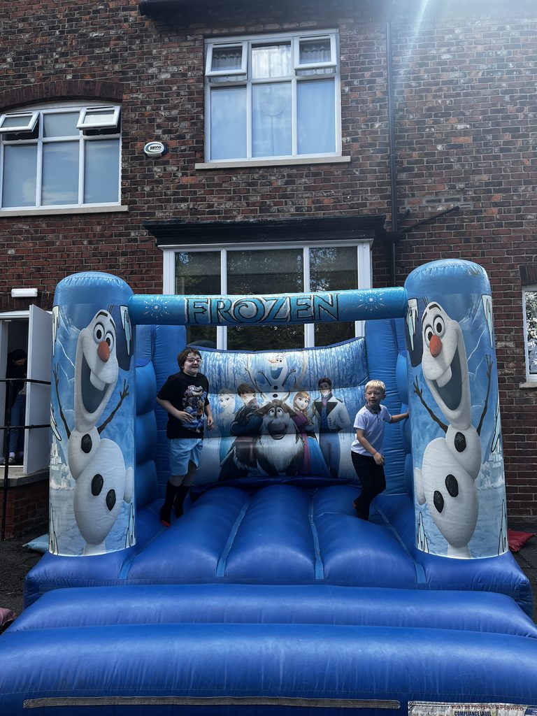 Two children jumping on an inflatable bouncy castle