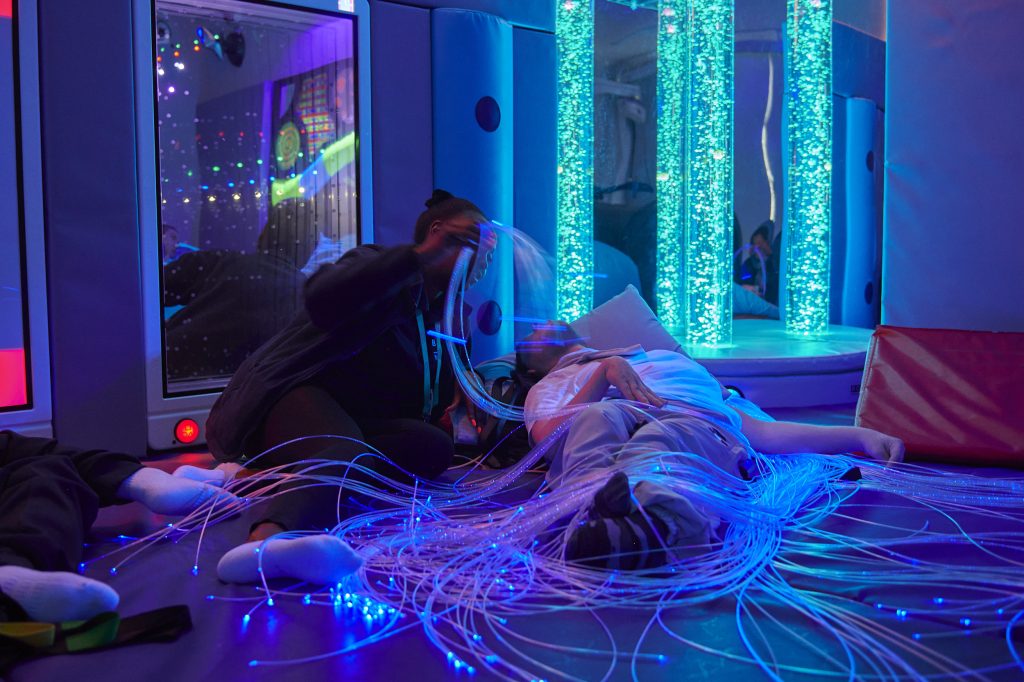 a student lying in a sensory room
