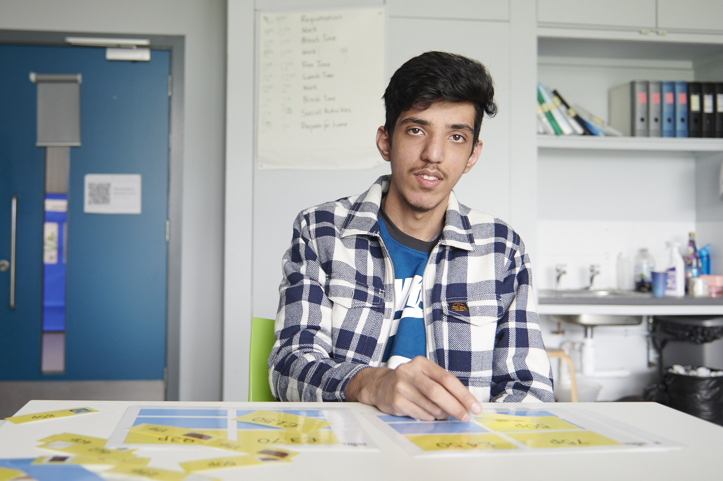 a student sat at a table with yellow cards in front of them