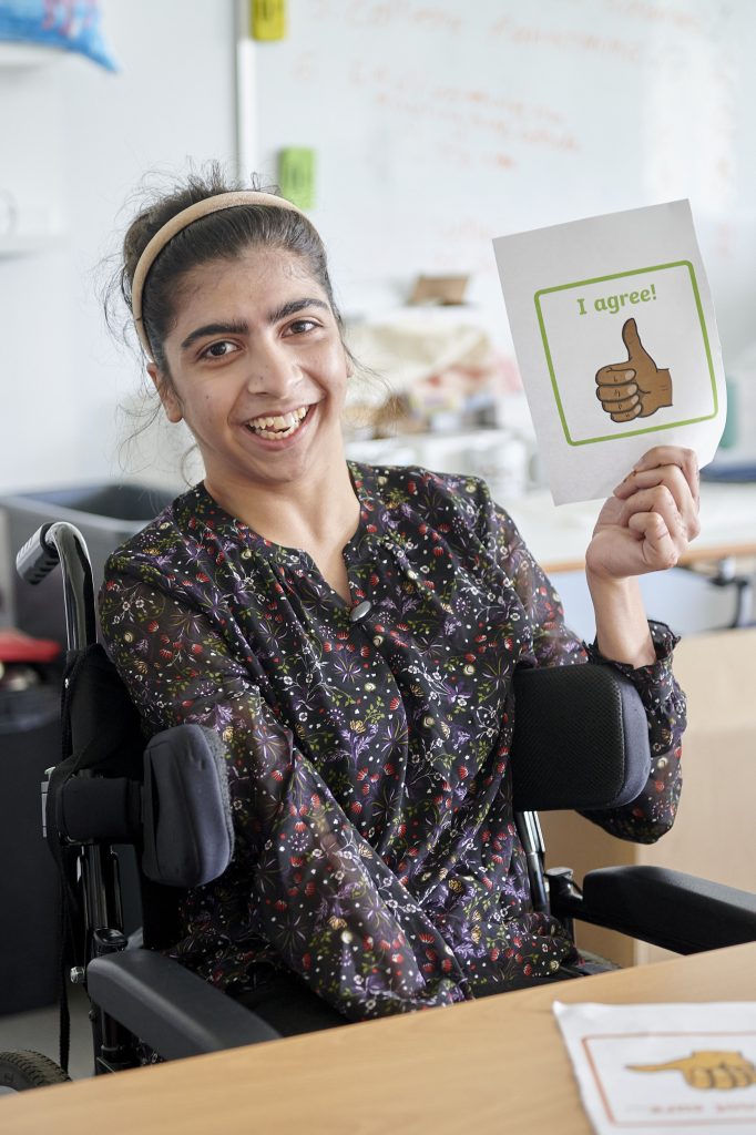 a student holding a card that says 'I agree'