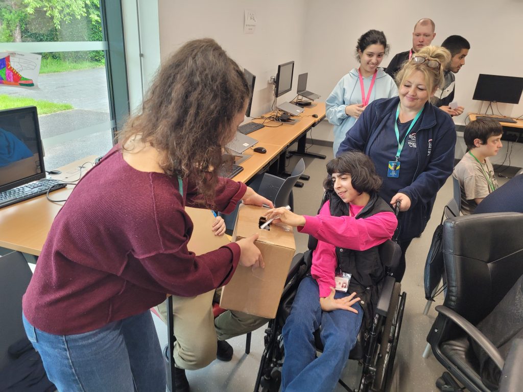 Syliana holding the polling station box while students line up to cast their votes. 