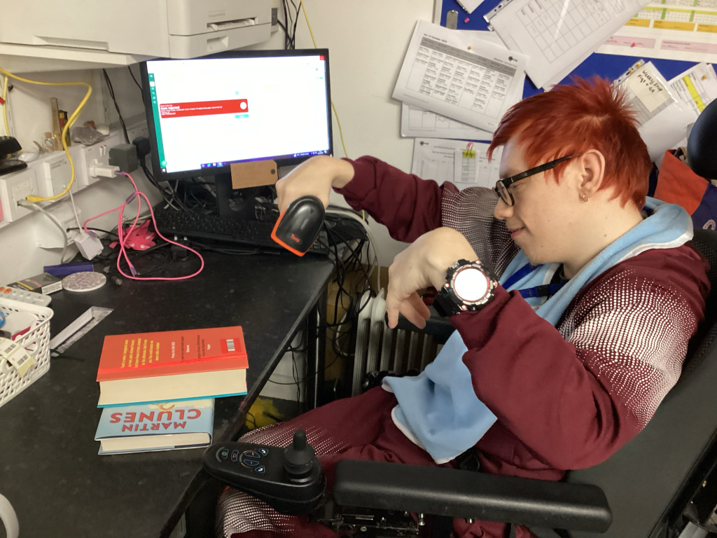 Rio is scanning books using a hand-held scanner. 