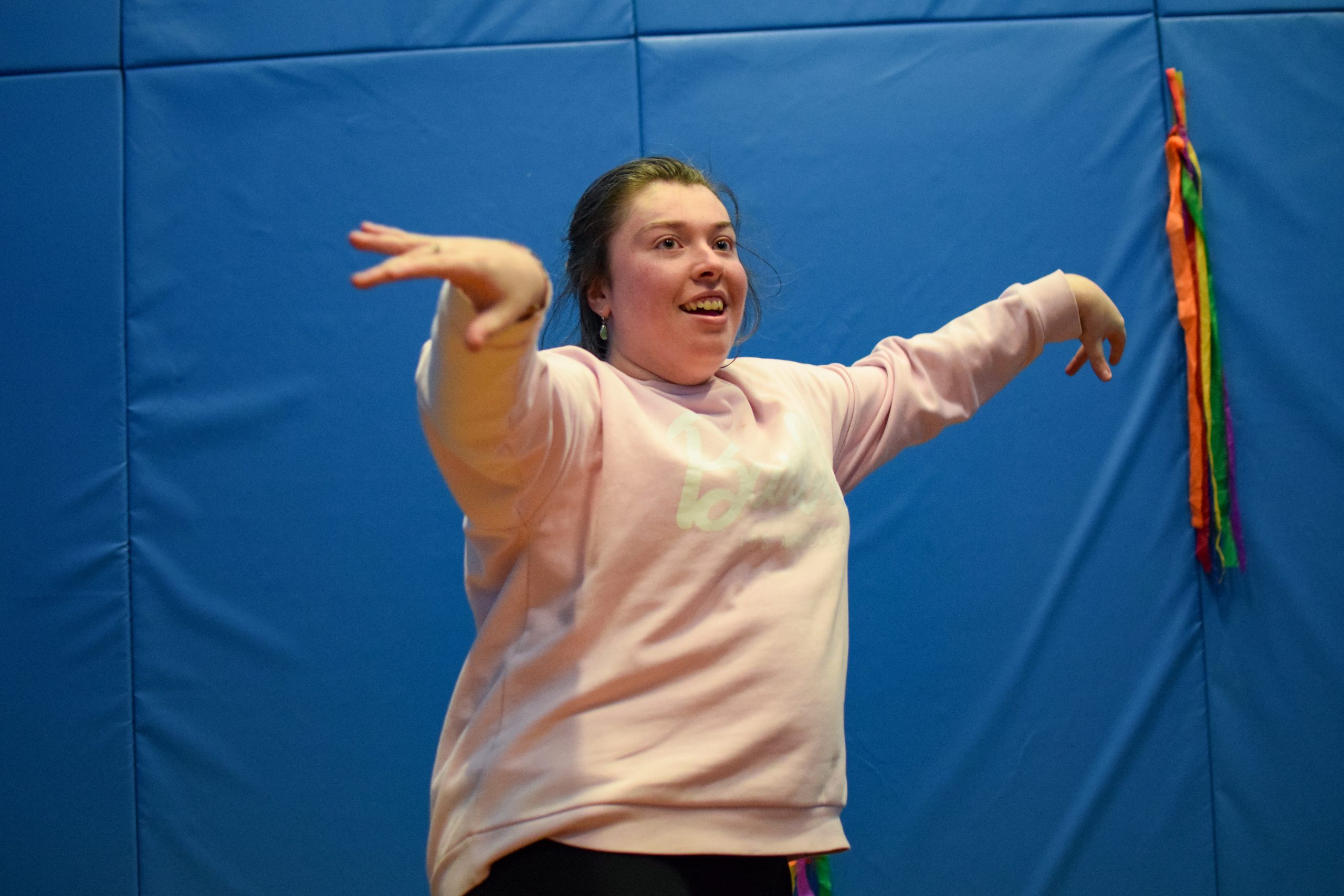 A young woman is posing after performing a gymnastics routine.