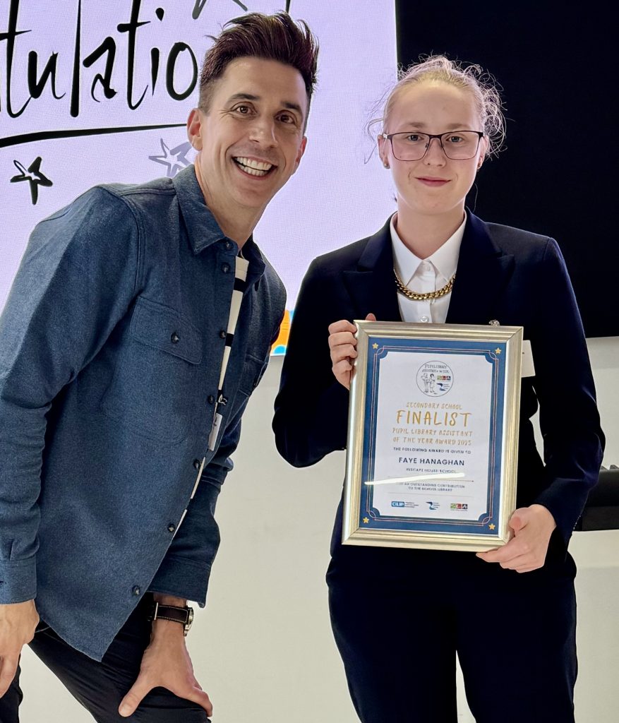 Faye is on stage, smiling as she receives her certificate.