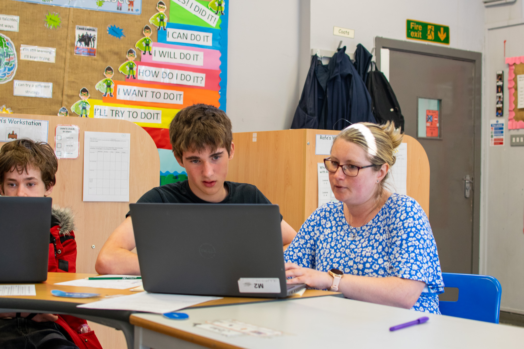 a teacher and a student looking at a laptop