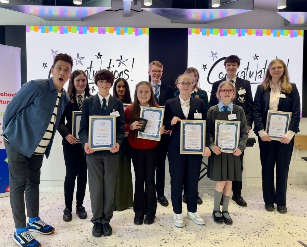 A group photo of all the finalists holding their certificates with the judging panel.