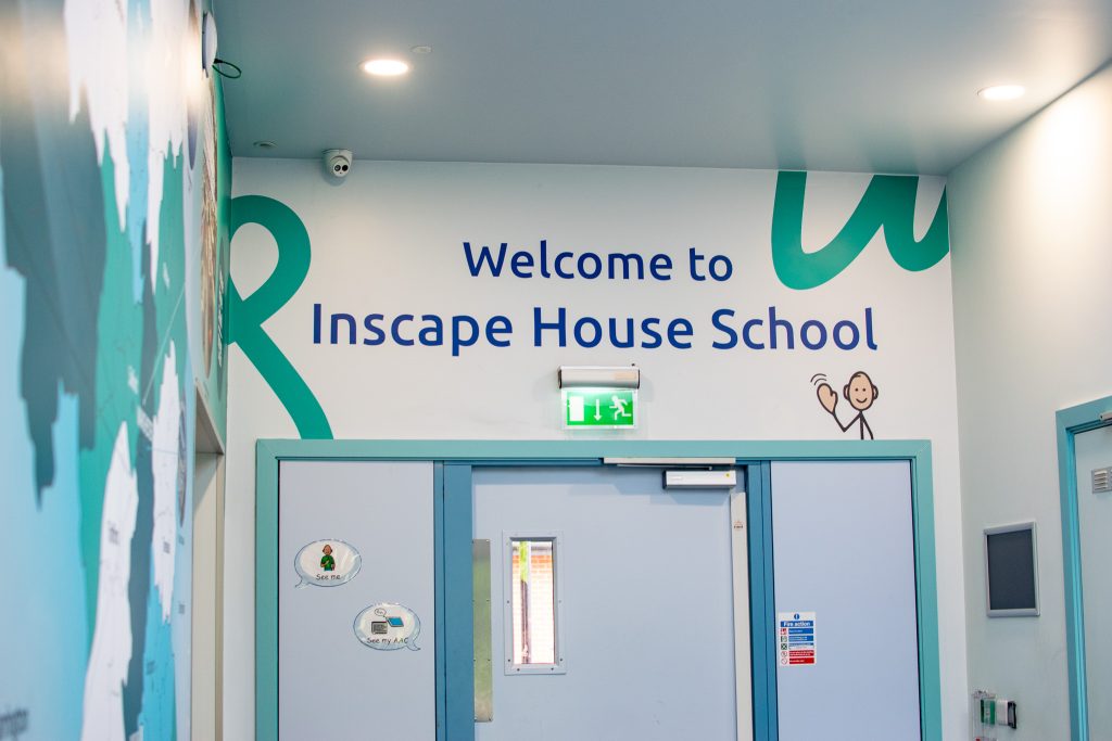 a painted wall that says 'welcome to inscape house school'